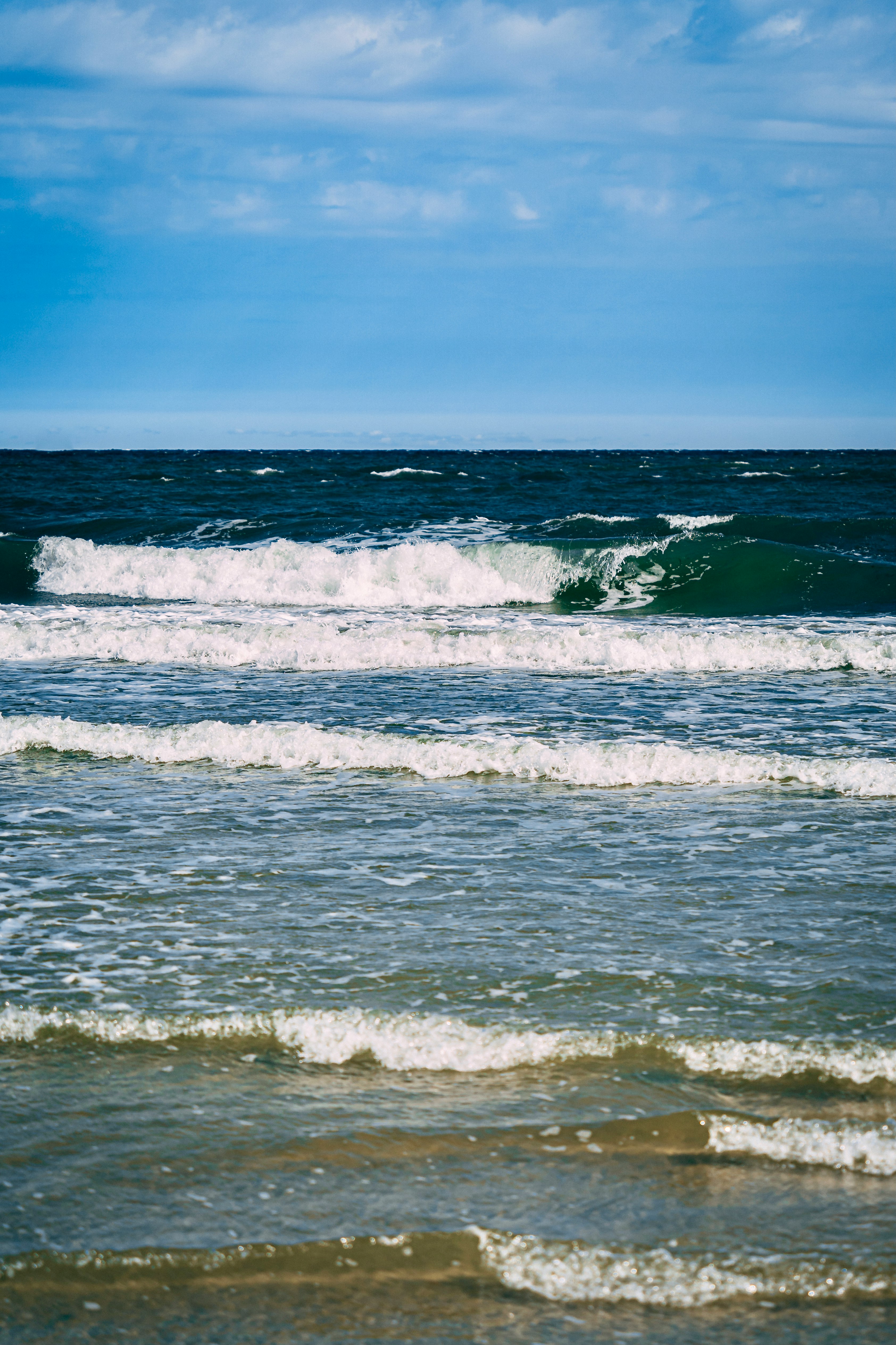 ocean waves under blue sky during daytime